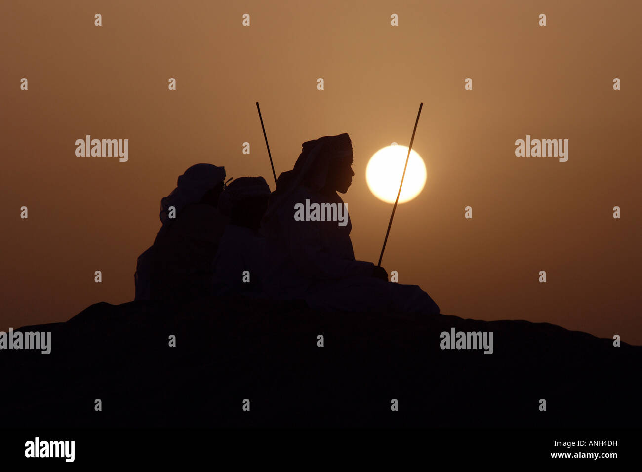 Gli uomini arabi nel deserto al tramonto Foto Stock