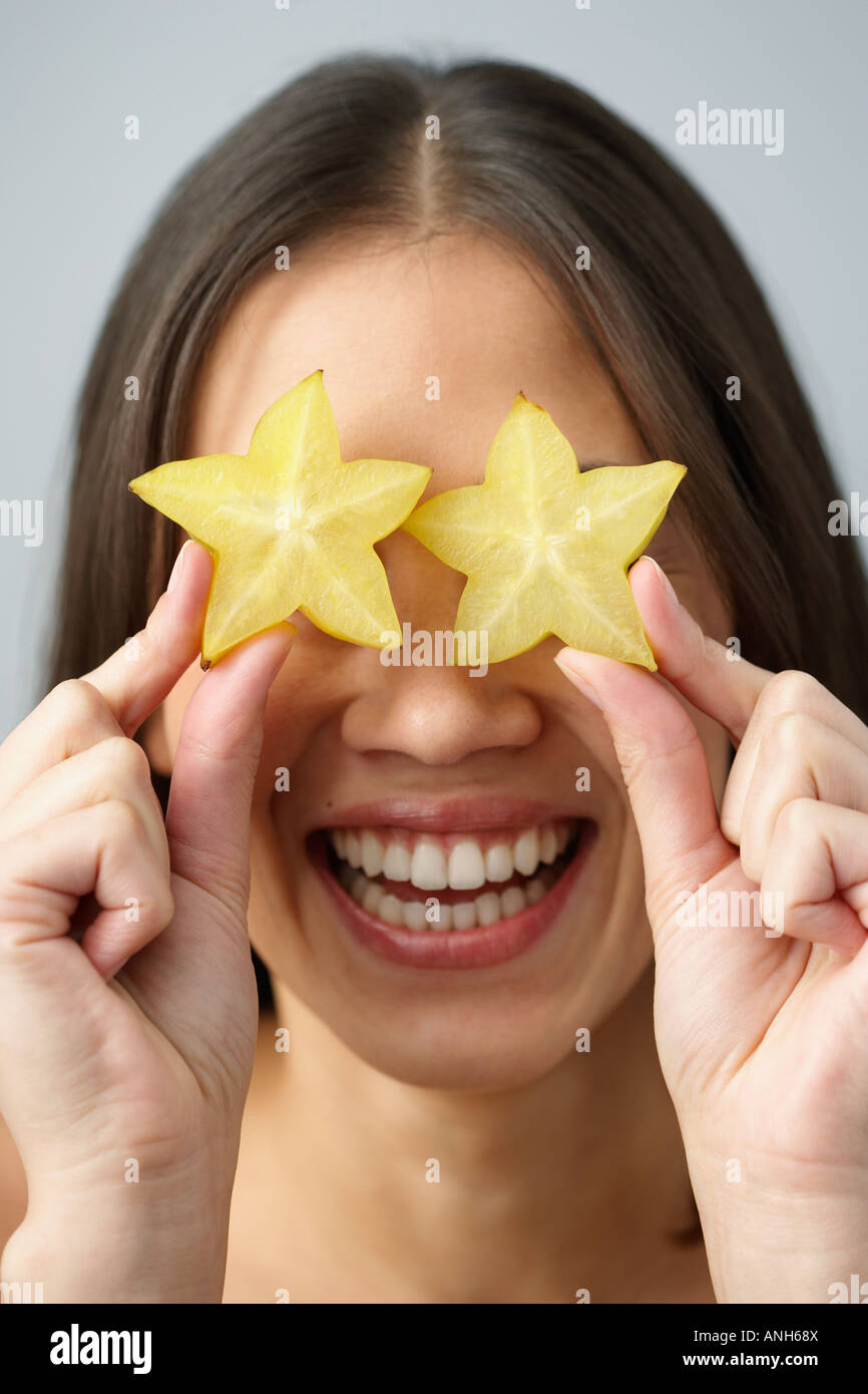 Donna asiatica azienda star frutti sopra gli occhi Foto Stock