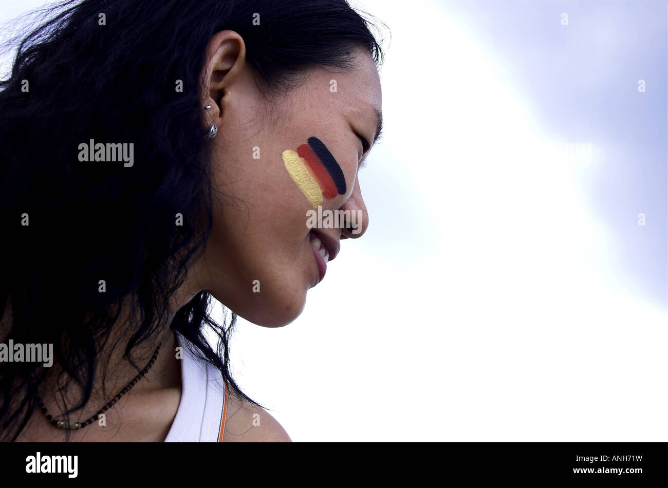 Bella donna cinese pittura bandiera tedesca sul viso Foto Stock