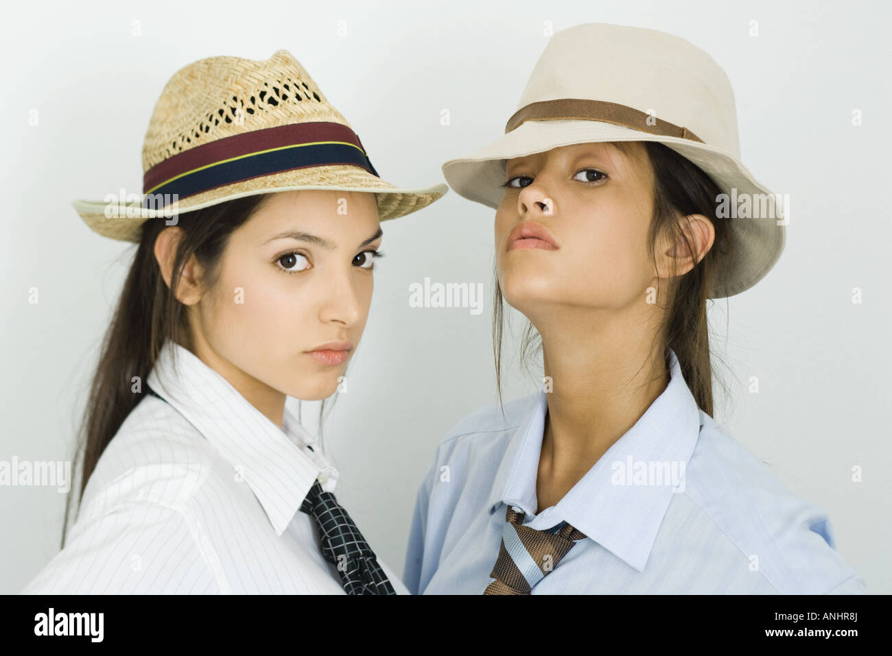 Due giovani amici di sesso femminile di indossare cappelli e cravatte, sia guardando la fotocamera Foto Stock