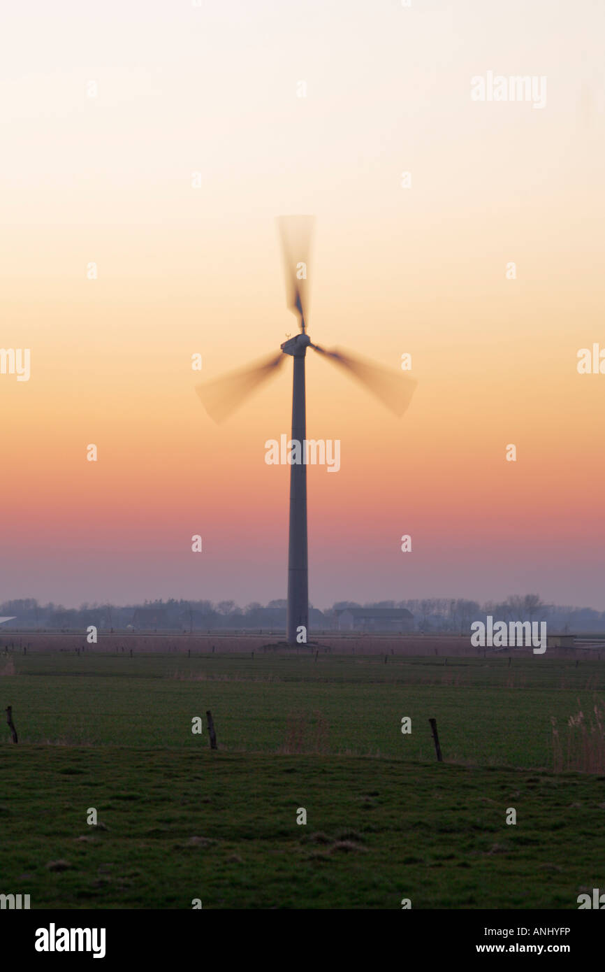 Turbina eolica in movimento al tramonto, Frisia settentrionale Germania ---- il mulino a vento mulino a vento energia alternativa la generazione di potenza Foto Stock