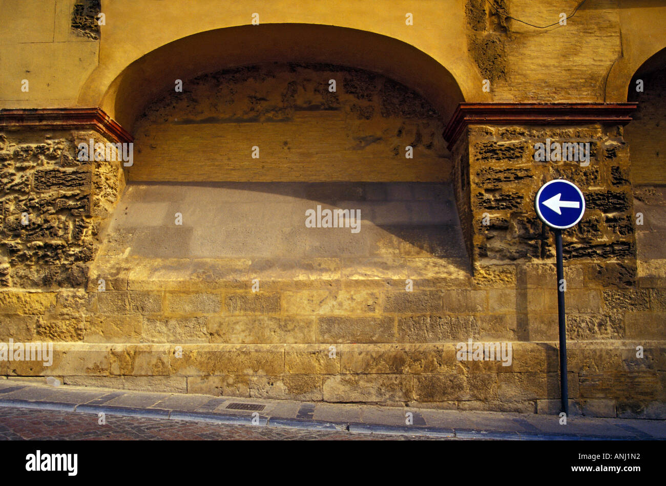 Scena di strada con il girare a sinistra cartello stradale a Cordoba, Spagna Foto Stock