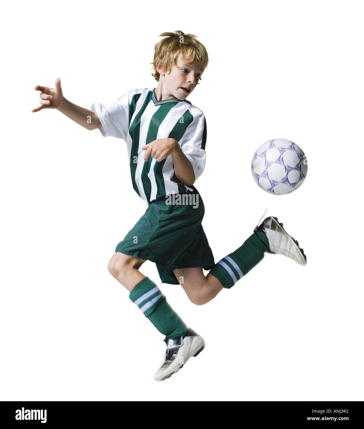 Ragazzo giovane calci ad un pallone da calcio Foto Stock