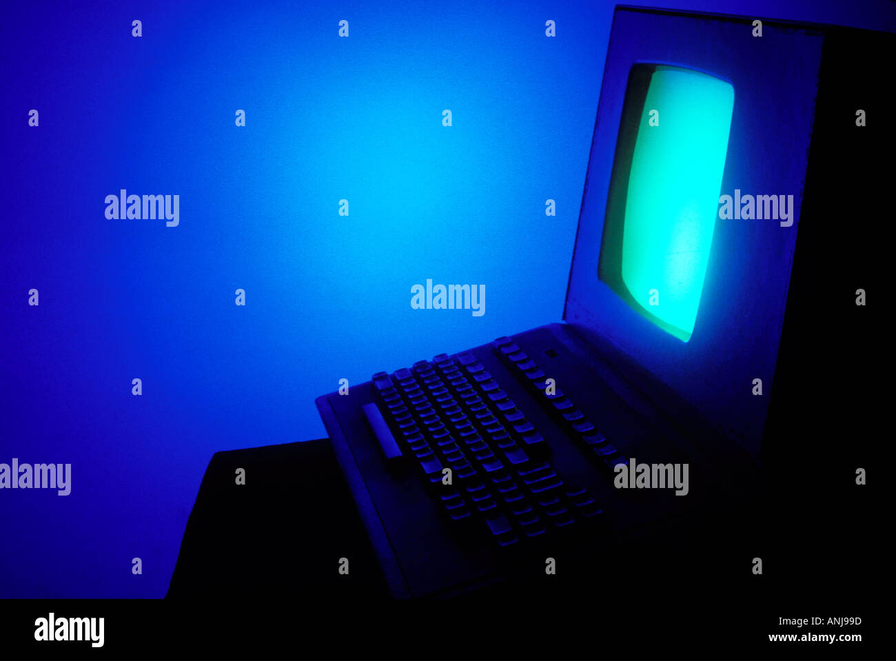 Computer con schermo verde in camera blu Foto Stock