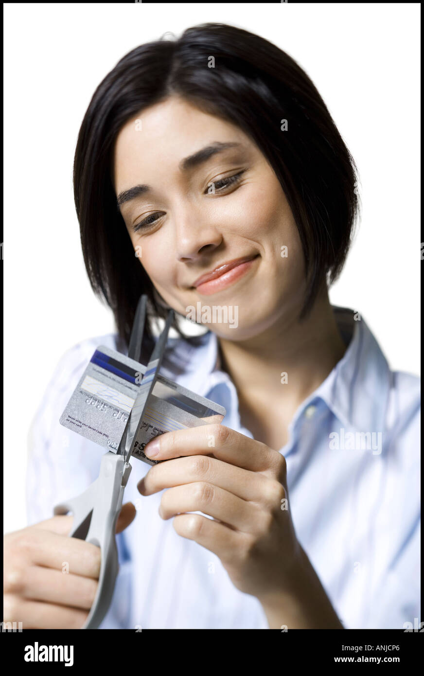In prossimità di una giovane donna di taglio di una carta di credito con un paio di forbici Foto Stock