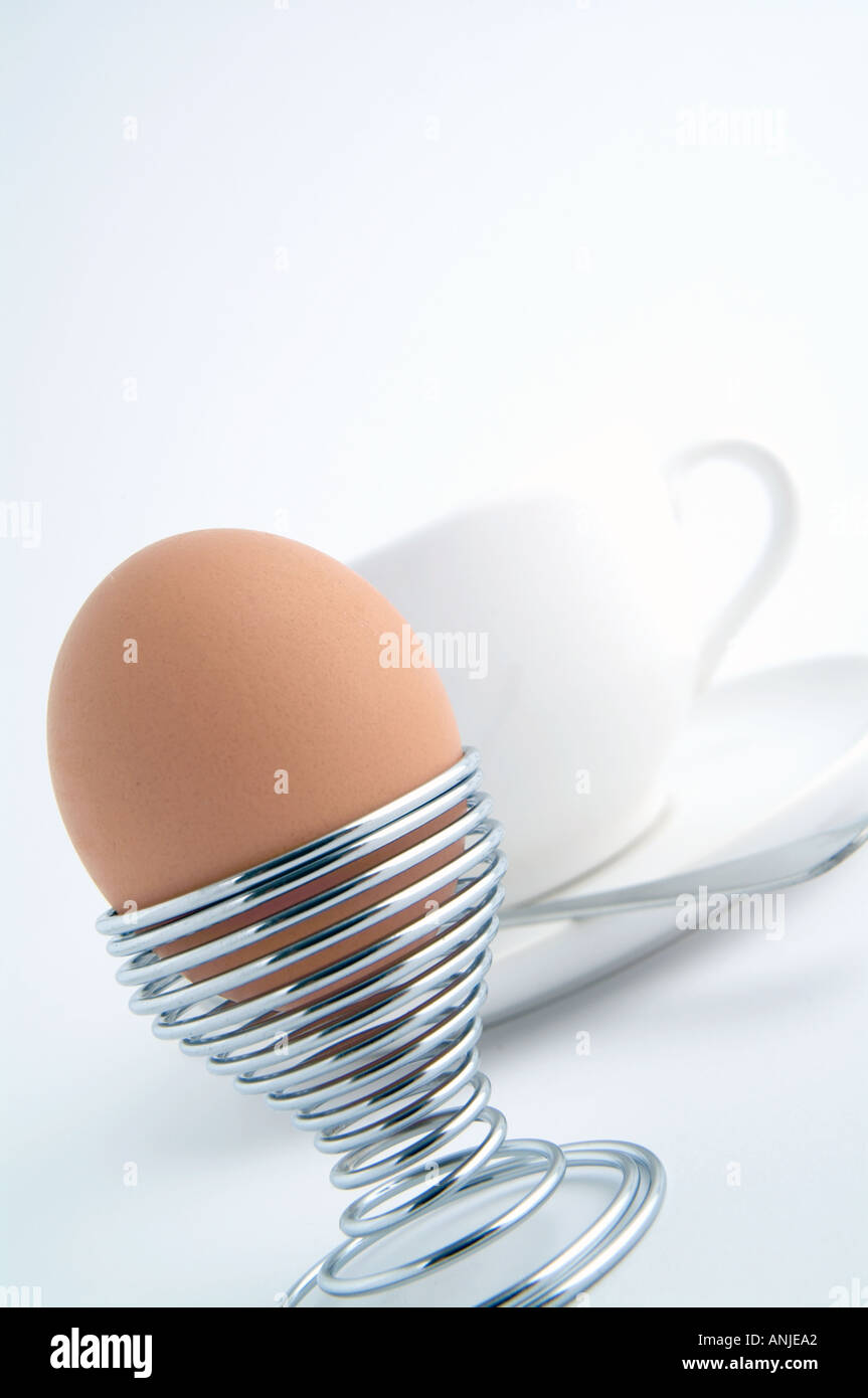 Uovo sodo in un uovo di filo di coppa con tazza bianca con piattino Foto Stock