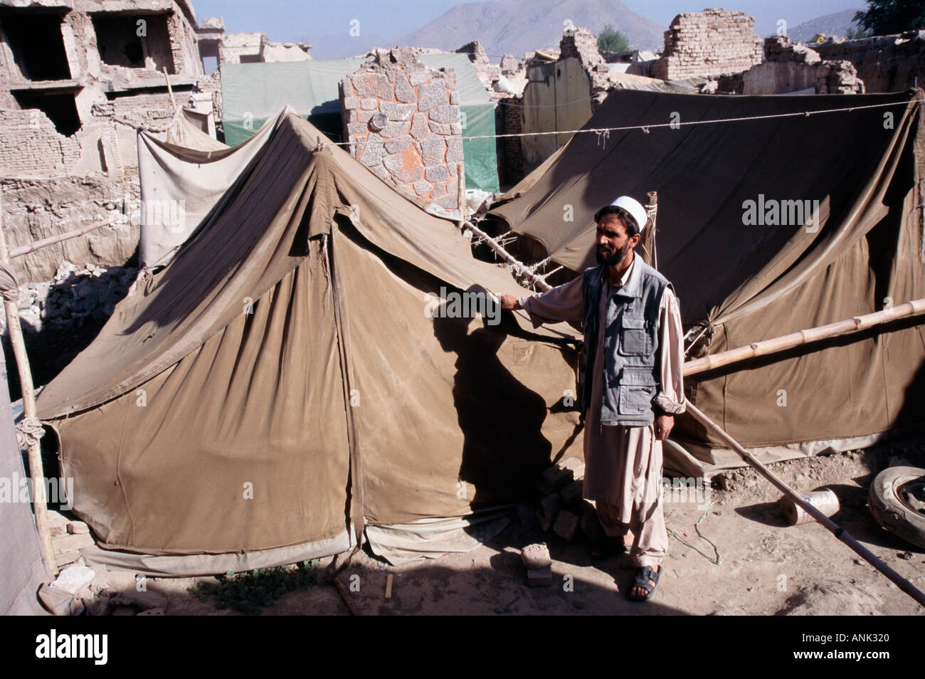 Profughi pakistani in piedi accanto al suo effettuare il cambio con tenda a Kabul in Afghanistan Foto Stock