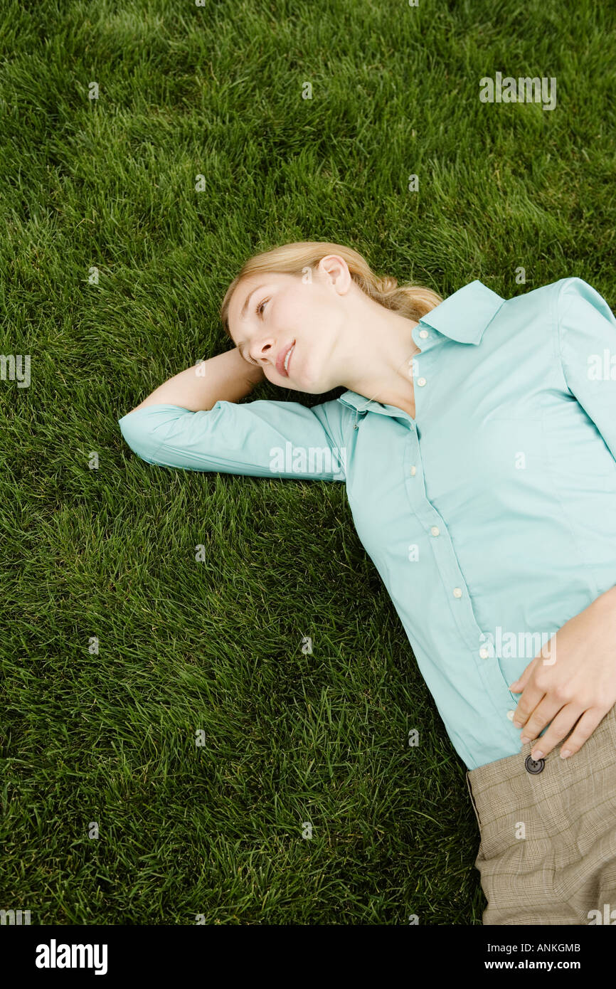 Angolo di alta vista di una giovane donna in appoggio su un prato Foto Stock