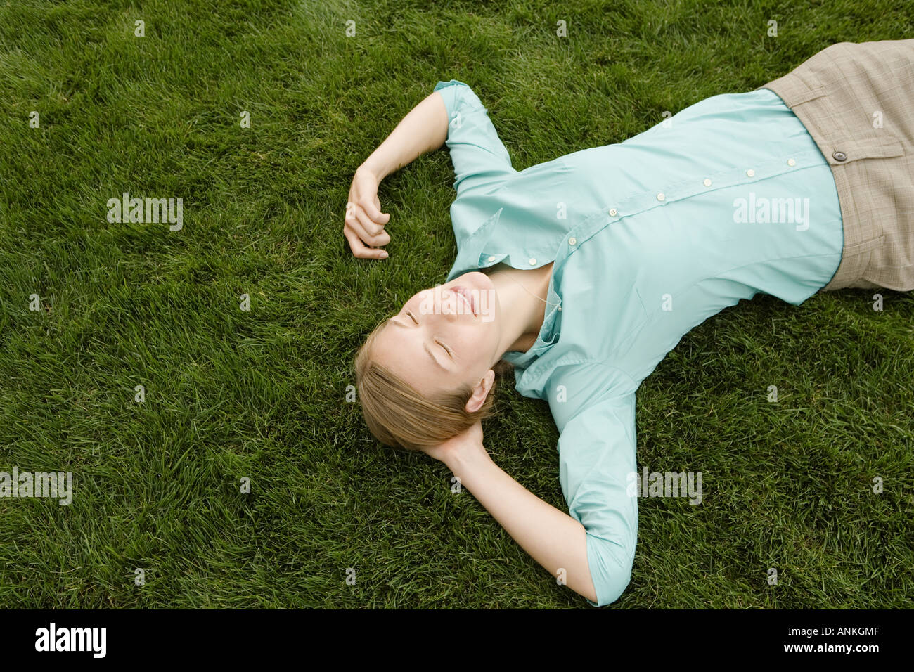 Angolo di alta vista di una giovane donna che dorme sull'erba Foto Stock