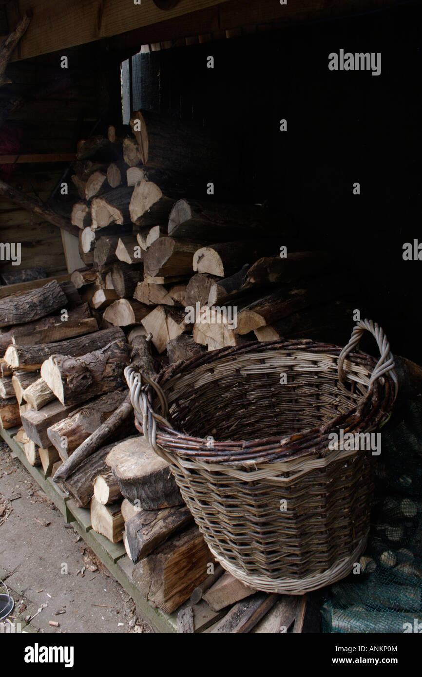 Legna da ardere e fatti a mano cesto di vimini nel capannone Foto Stock