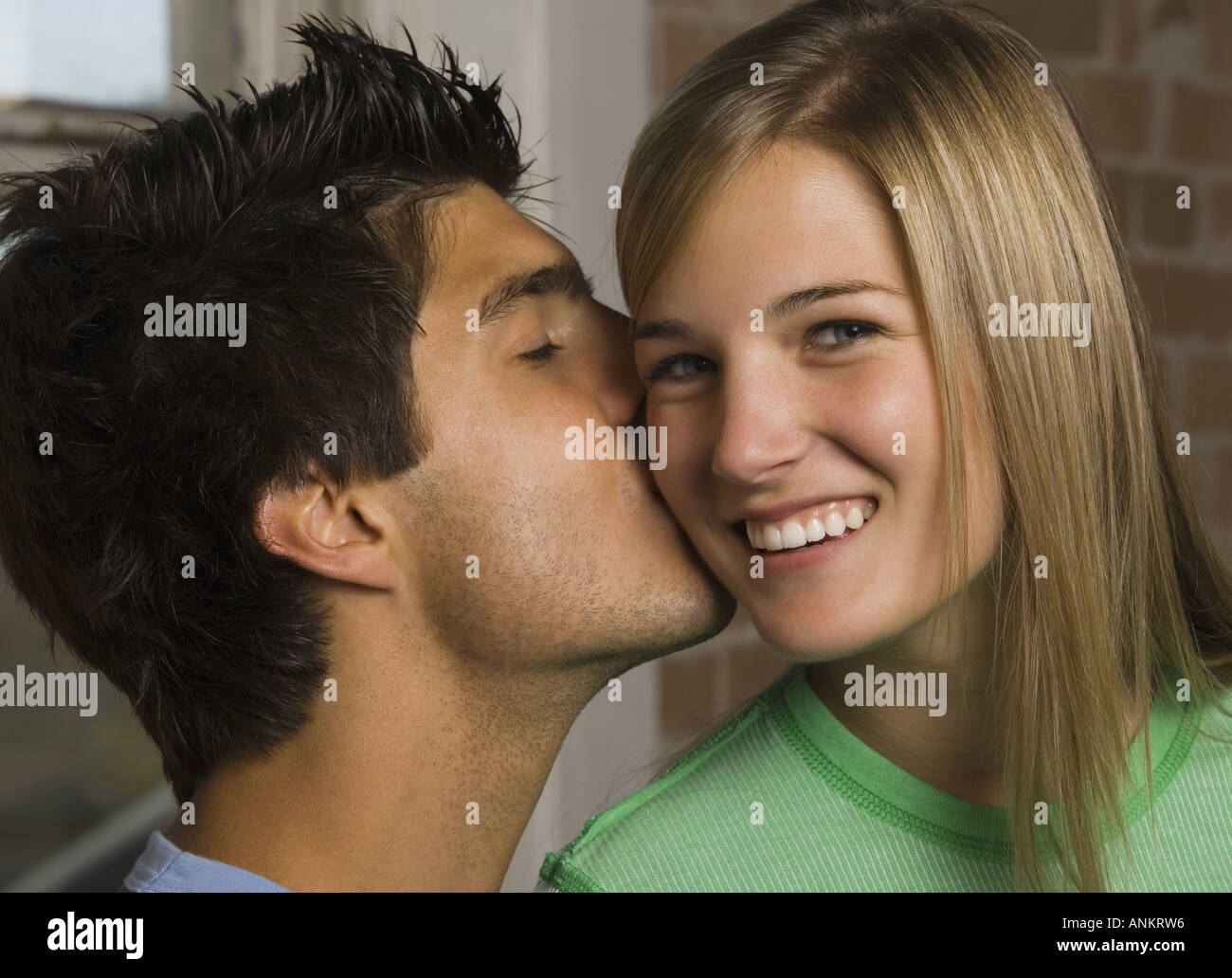 Close up di un giovane uomo di baciare una giovane donna Foto Stock