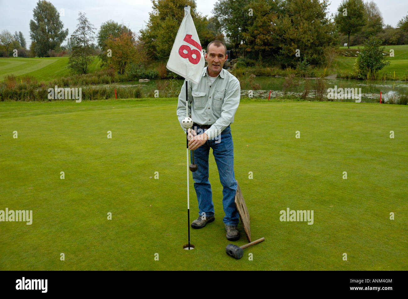 Capo Verde-keeper cambiando un foro sul campo da golf. Foto Stock