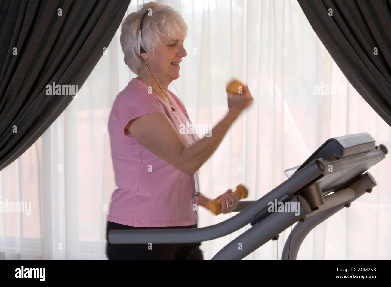 Senior donna lavora su un tapis roulant mill Foto Stock