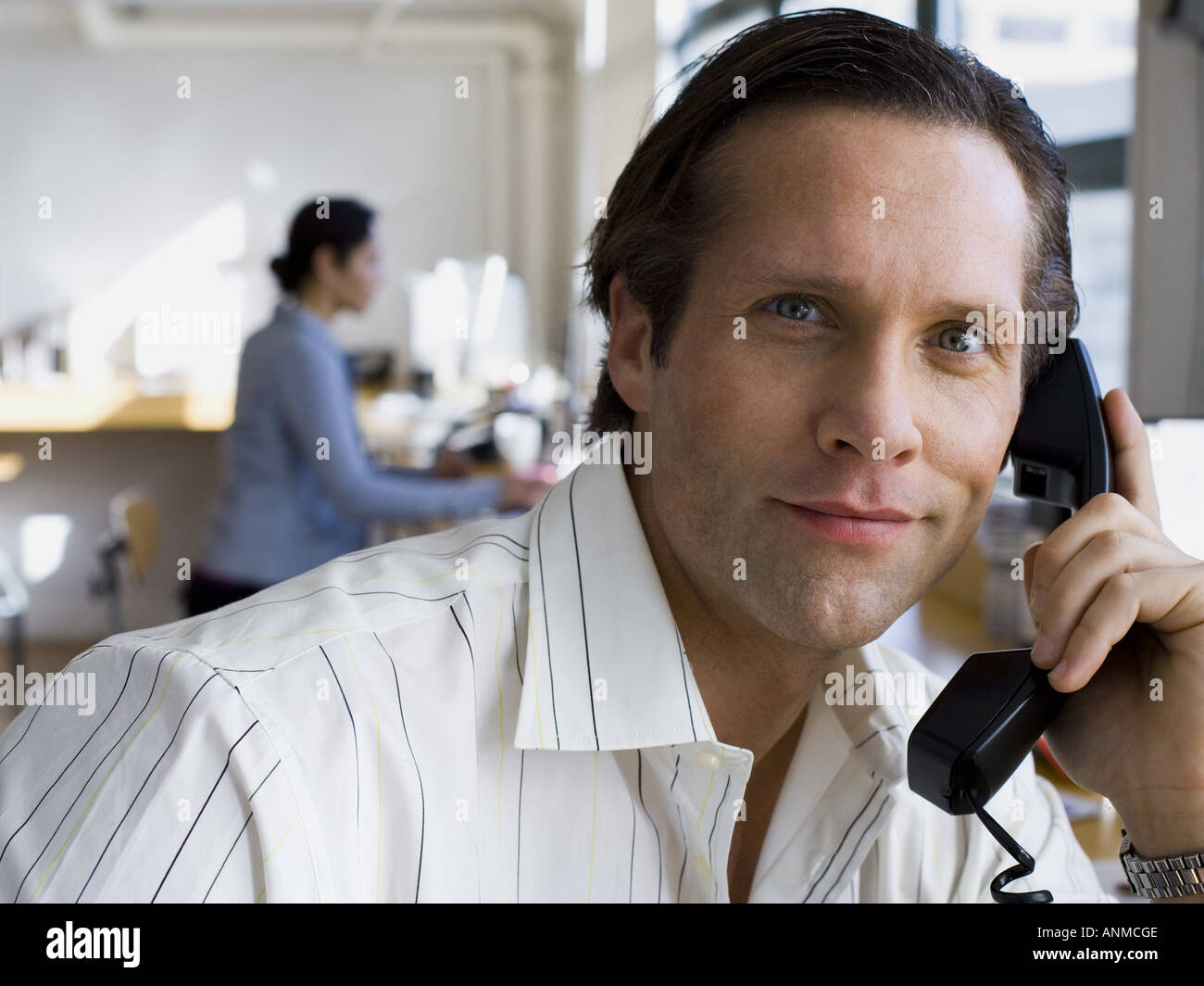 Ritratto di una metà uomo adulto parlando al telefono in un ufficio Foto Stock