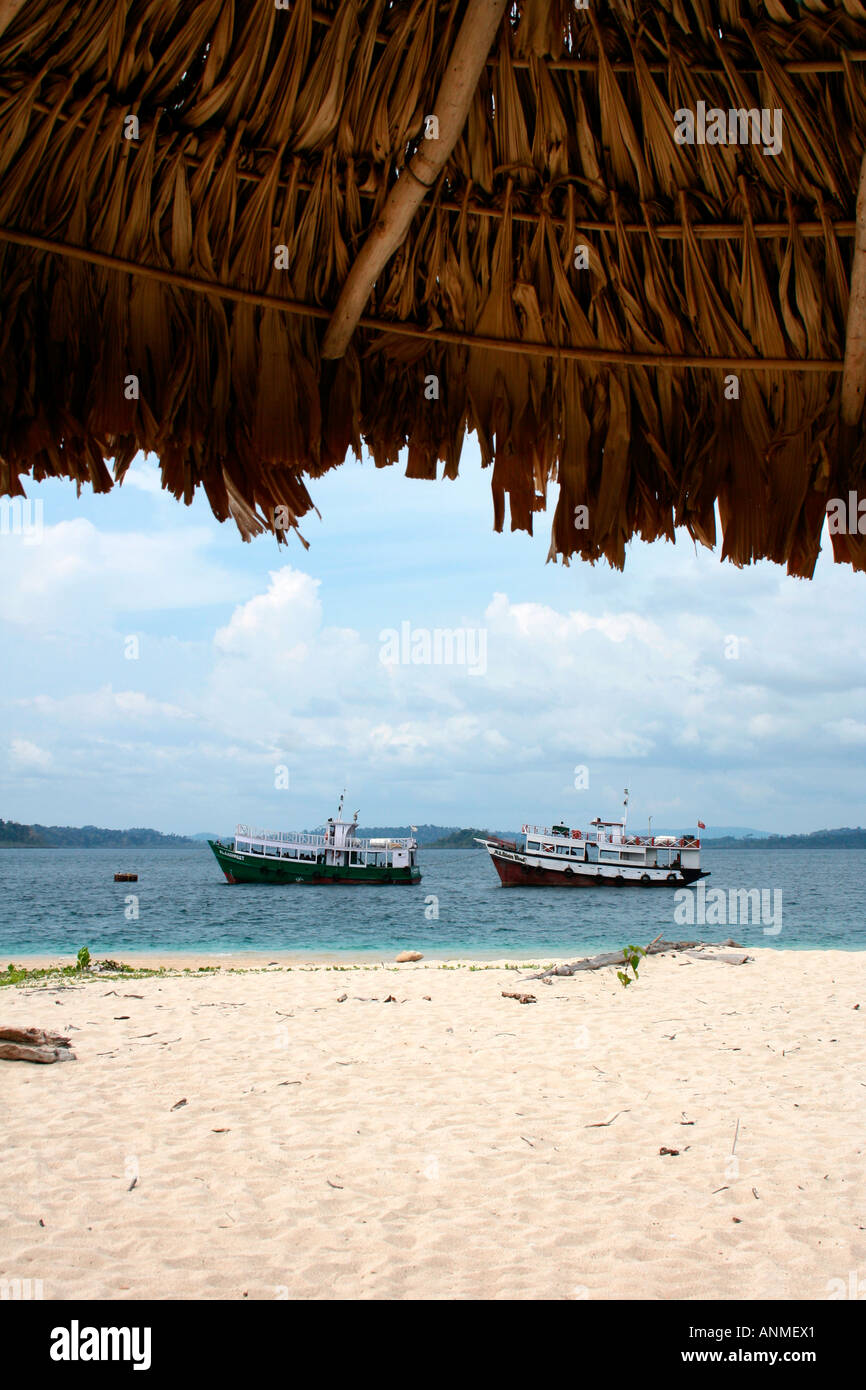 L'immagine di due imbarcazioni in avvicinamento alla boa Jolly beach Andaman delimitato superiormente da una porzione del rifugio sulla costa Foto Stock