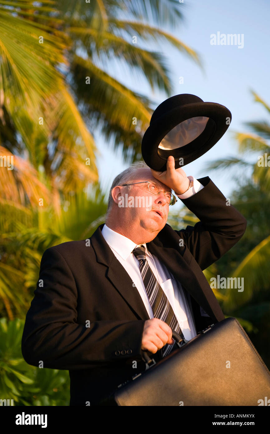 Surriscaldamento imprenditore occidentale nel cappello bowler e business suit tergi sudore dal brow Foto Stock