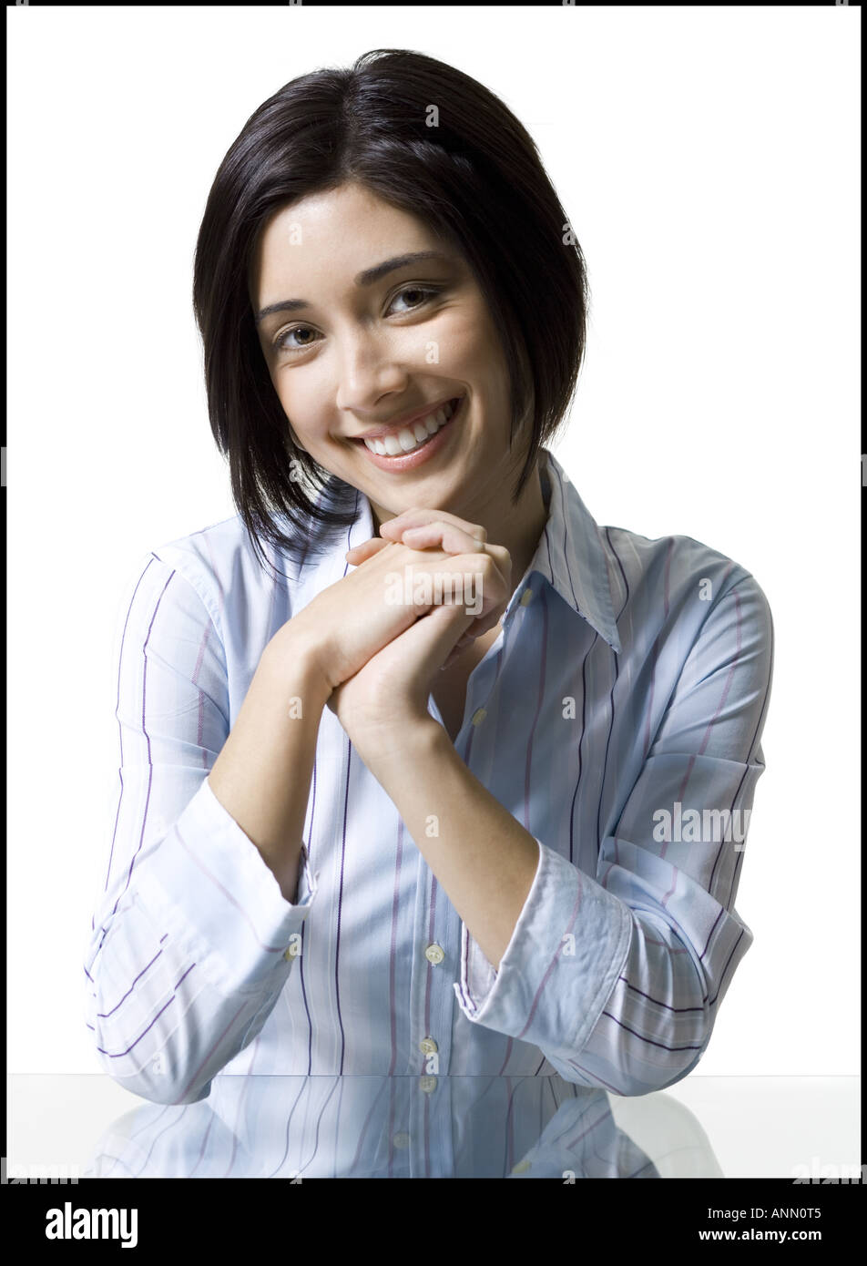 Ritratto di una giovane donna sorridente con la sua mano sulla mento Foto Stock