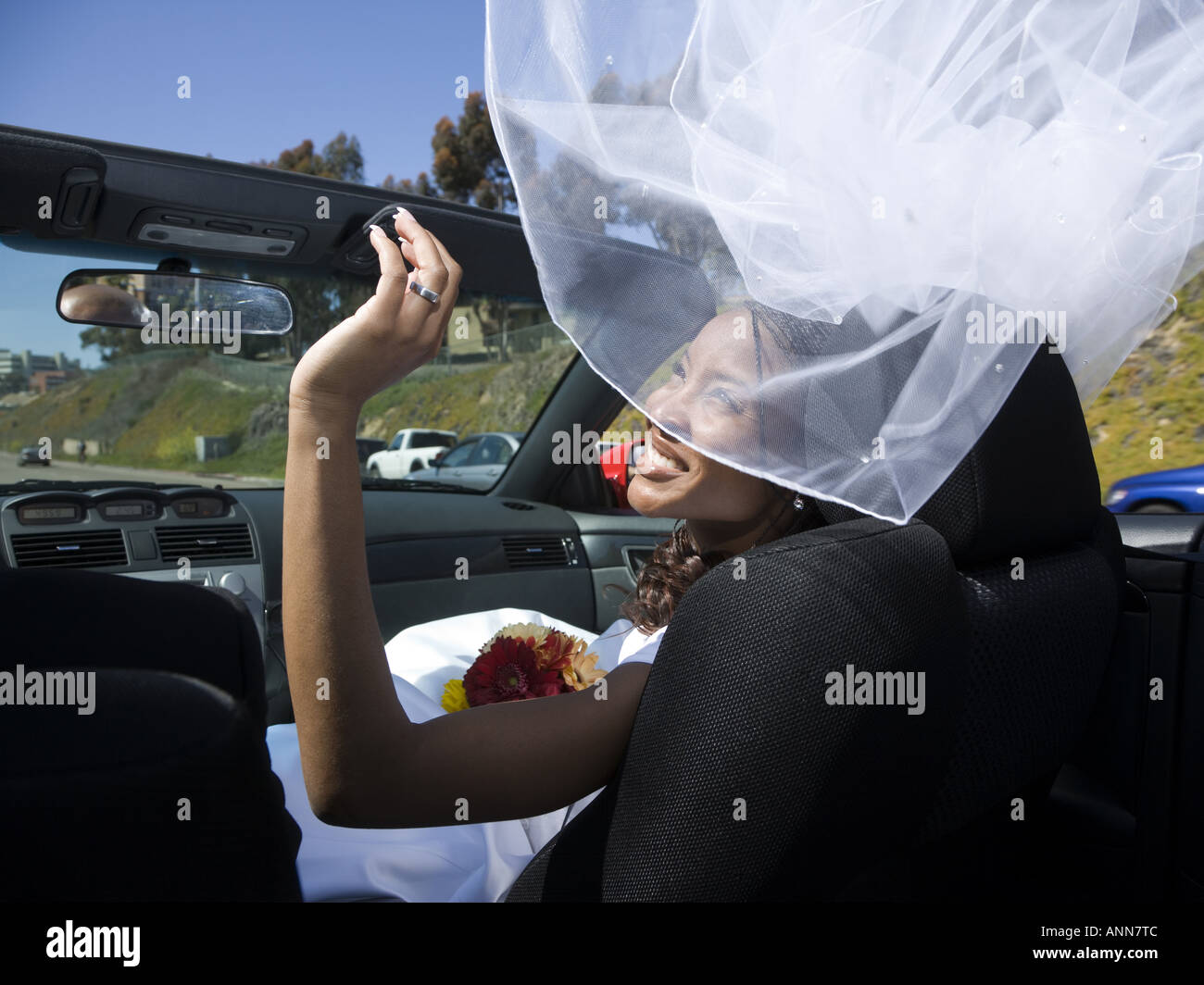 Vista posteriore di una sposa seduta con il suo sposo in una vettura convertibile Foto Stock