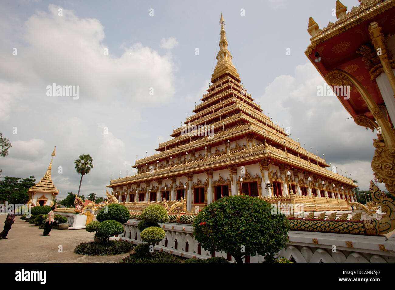 Ingresso anteriore della Wan di Nong Muang tempio il Chedi contro un pallido cielo blu in Khon Kaen angolo di un tetto di un altro edificio sulla destra della foto Foto Stock