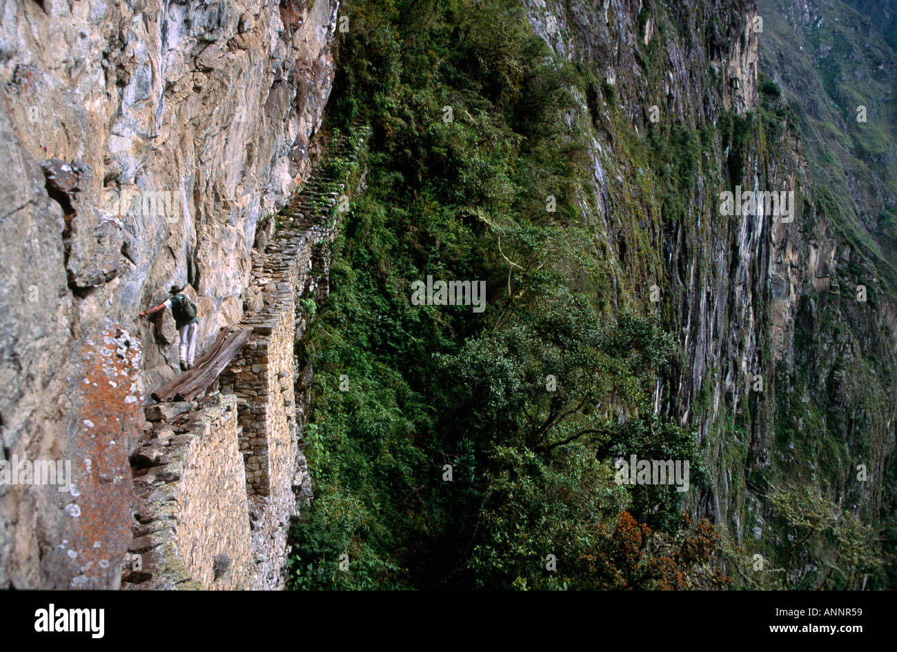 Fotografo Andrea Holt rendendo pericoloso attraversamento del ponte levatoio inca dalla scogliera a bordo le montagne vicino al Cammino Inca di Machu Picchu Perù 199302 Foto Stock