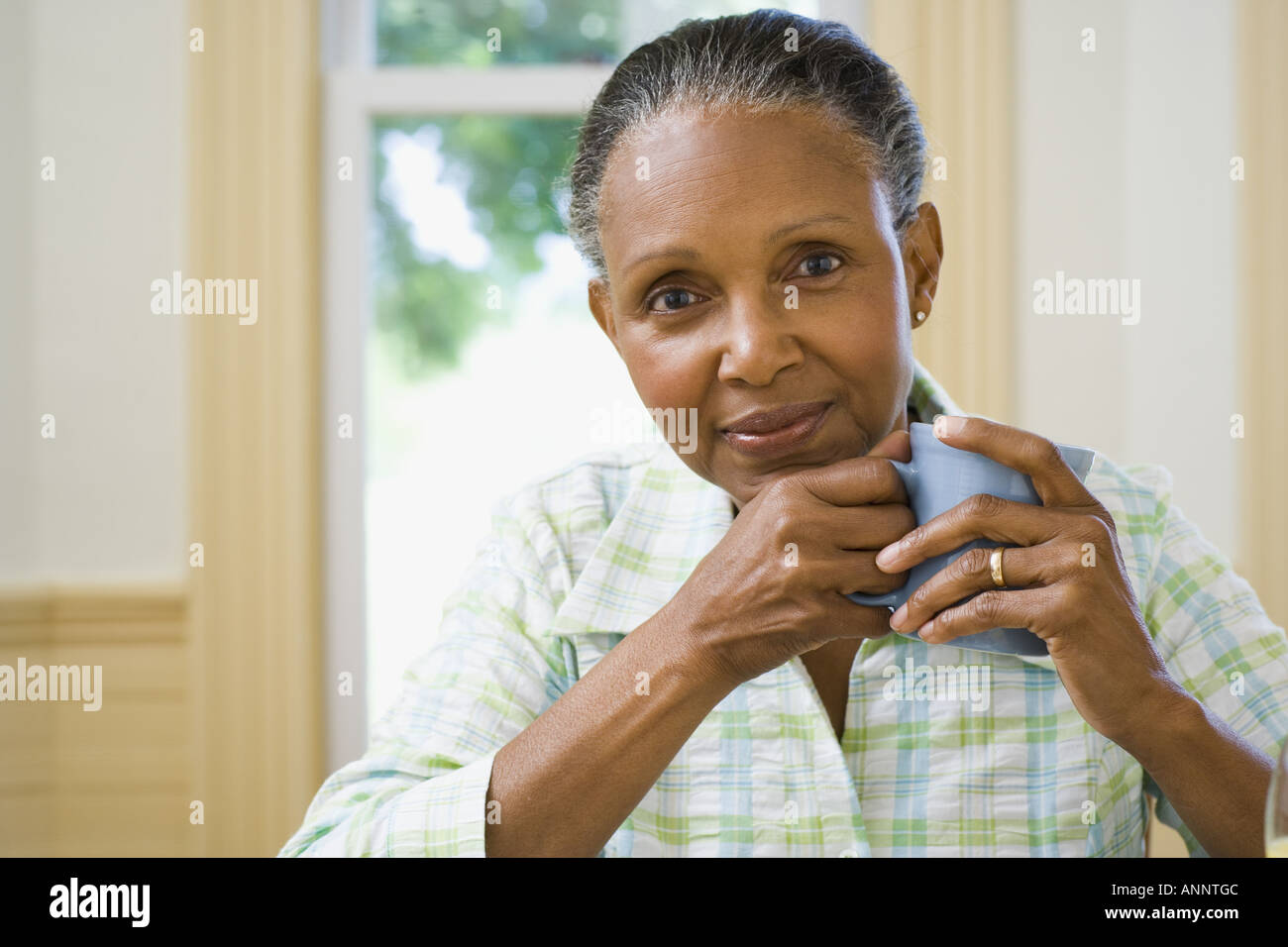 Ritratto di una donna senior in possesso di una tazza di caffè Foto Stock
