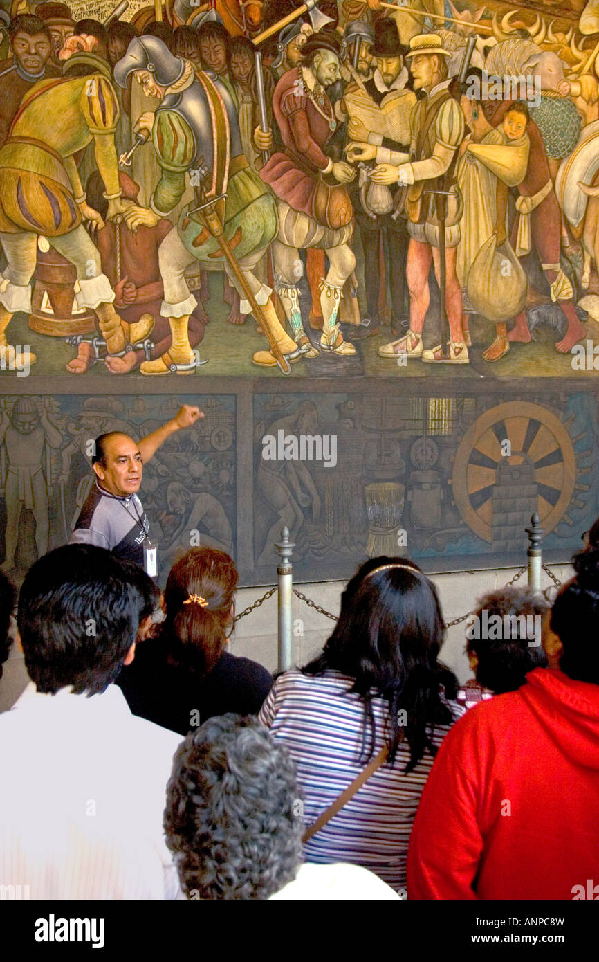 Una guida turistica che mostra ai turisti un murale dipinto da Diego Rivera presso il Palazzo Nazionale a Città del Messico MESSICO Foto Stock