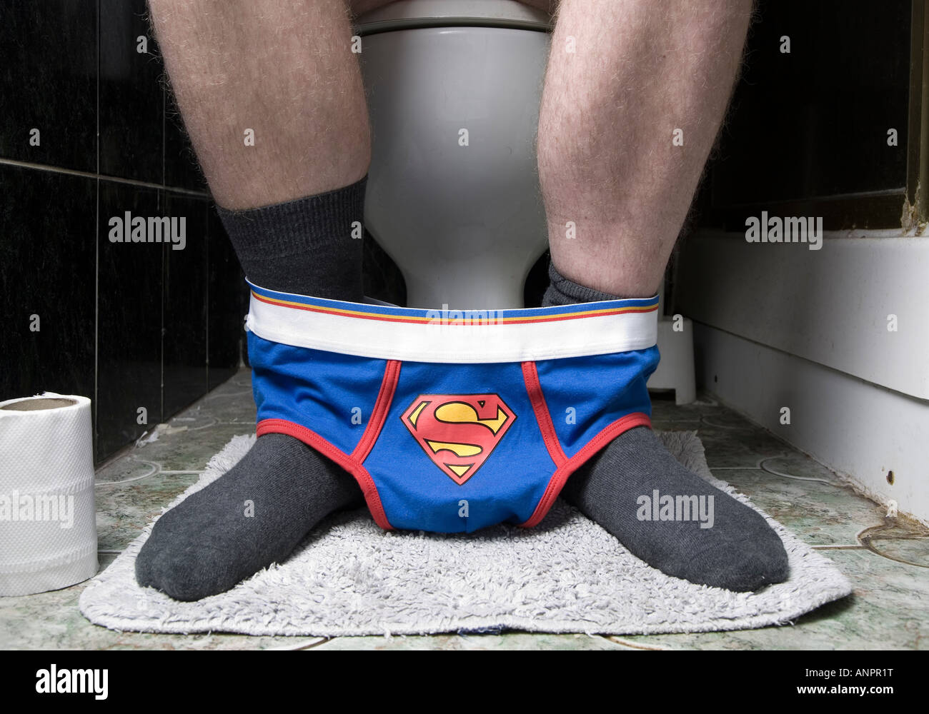 Un maschio sul wc con superman mutande intorno alle sue caviglie Foto stock  - Alamy