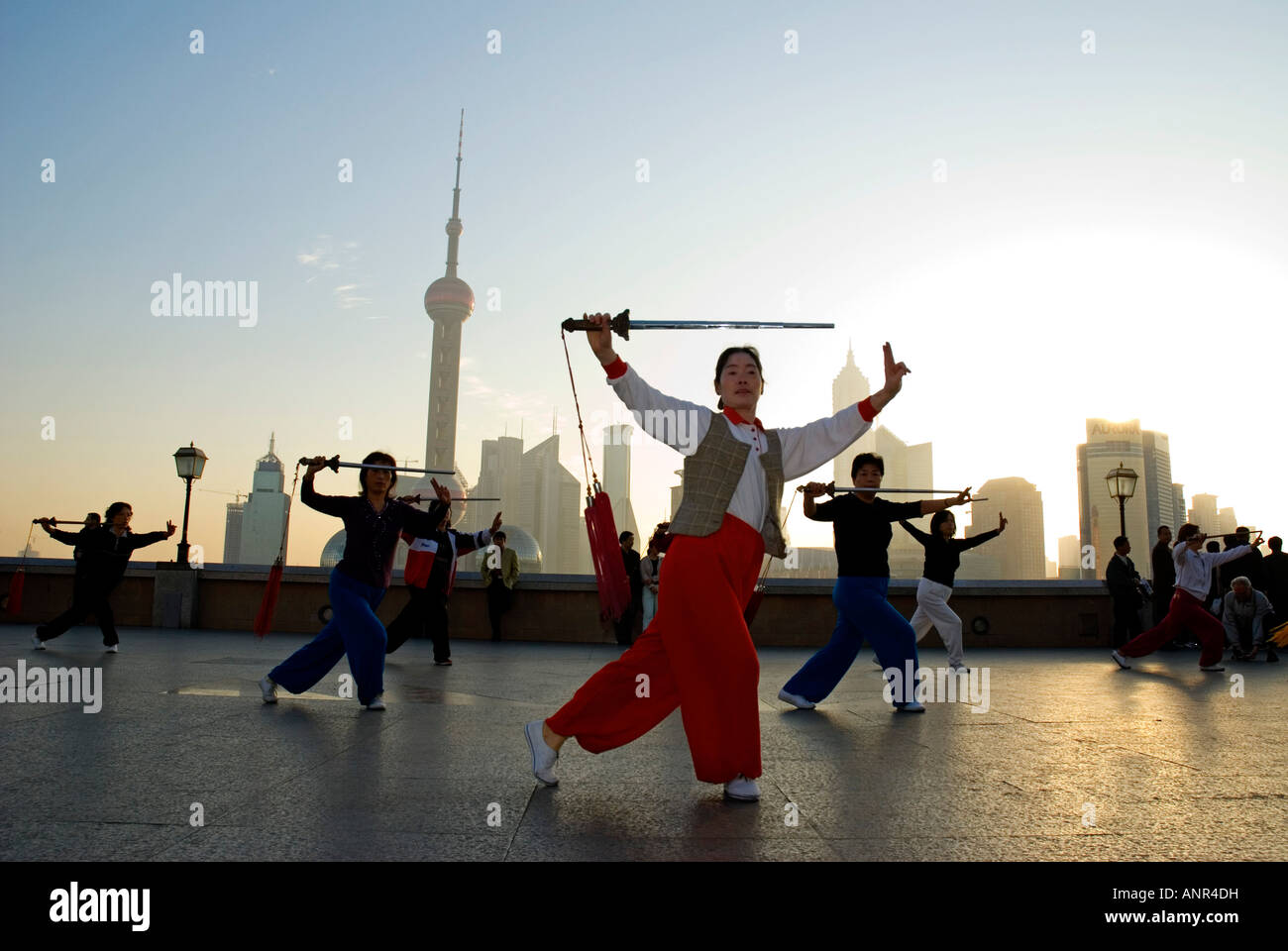 Donne Squadra facendo ginnastica mattutina con spade sul Bund, Shanghai, Cina Foto Stock