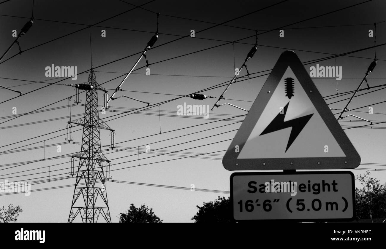 Overhead cavo di potenza segnale di avvertimento per i treni con linee elettriche in background Foto Stock