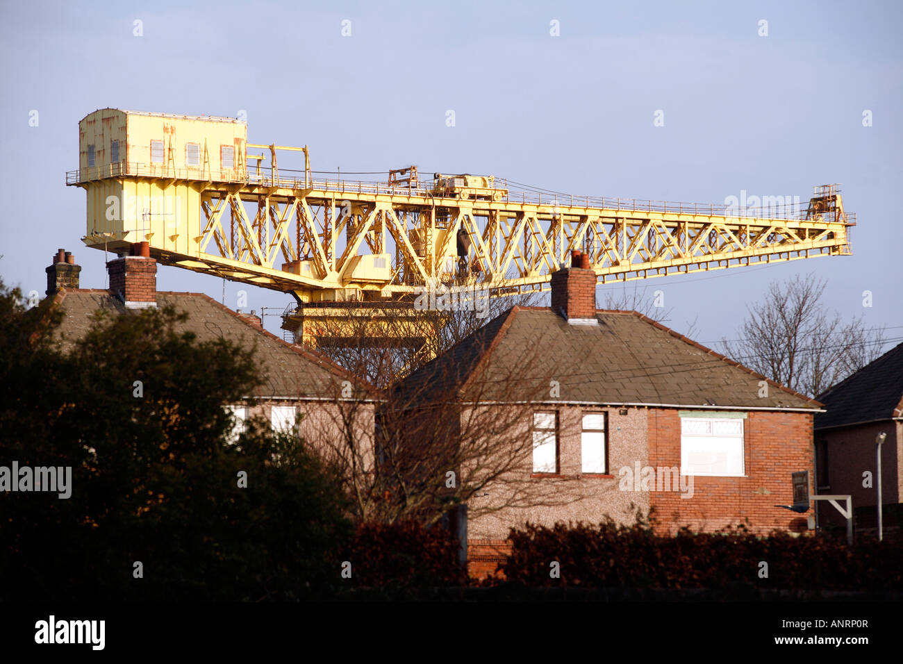 Il gigante di gru di cantiere che sovrasta 1930 edilizia residenziale in Barrow-in-Furness, Cumbria Foto Stock