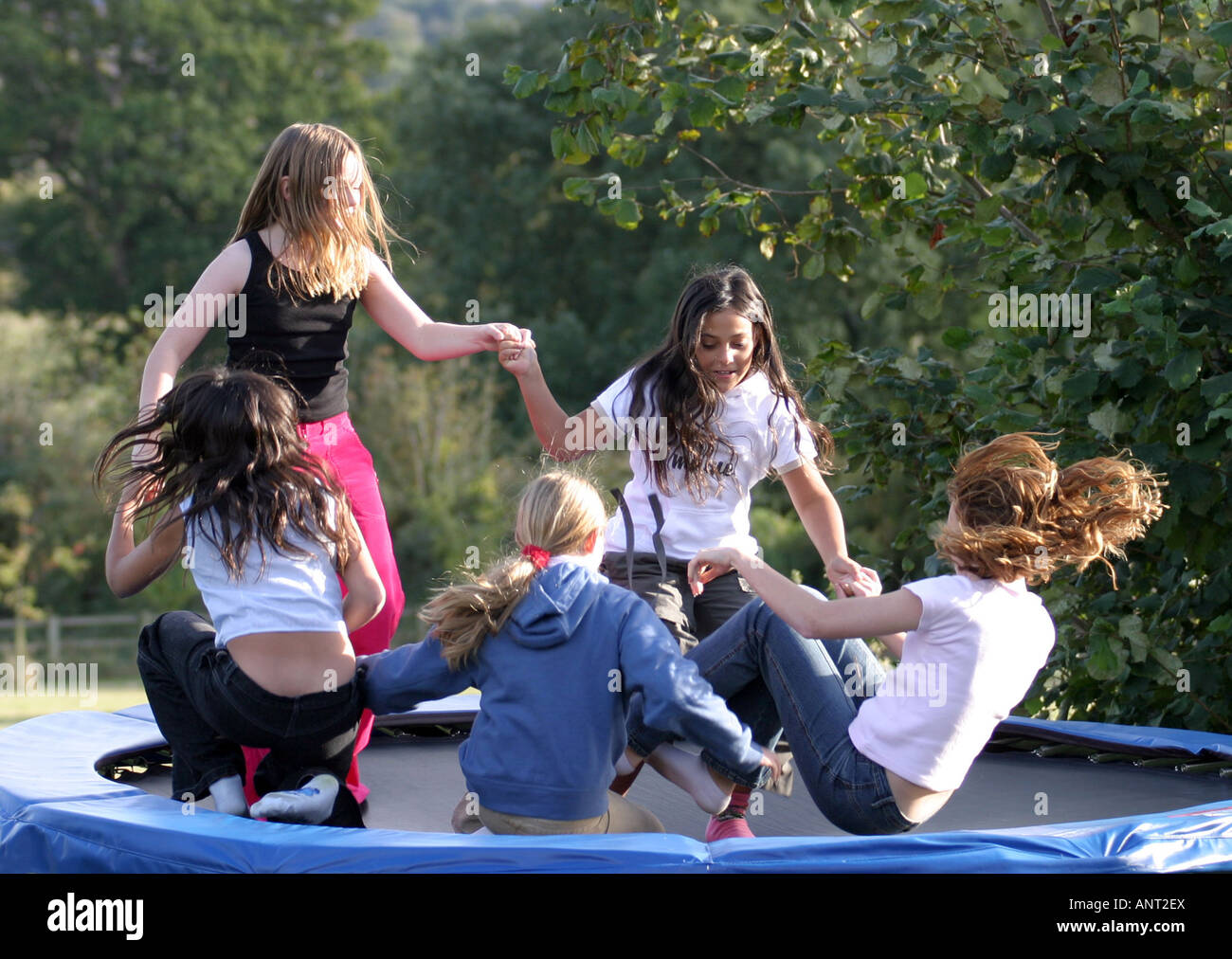 Cinque ragazze avente un grande tempo all'aperto, giocando su un trampolino, WILTSHIRE REGNO UNITO Foto Stock