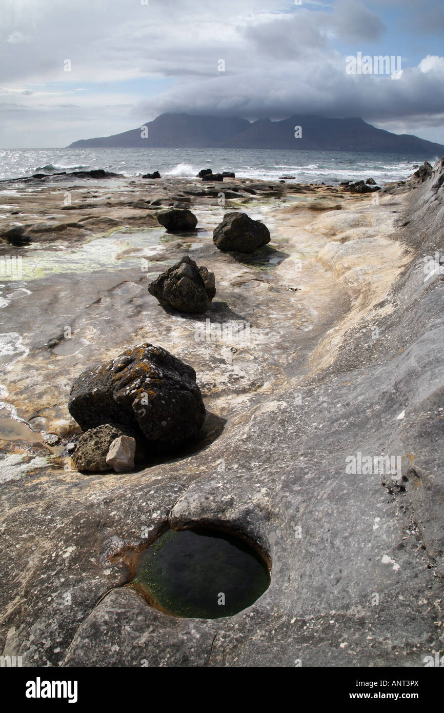 Rocce sulla riva, Isola di Eigg guardando verso il rum, Scozia Foto Stock