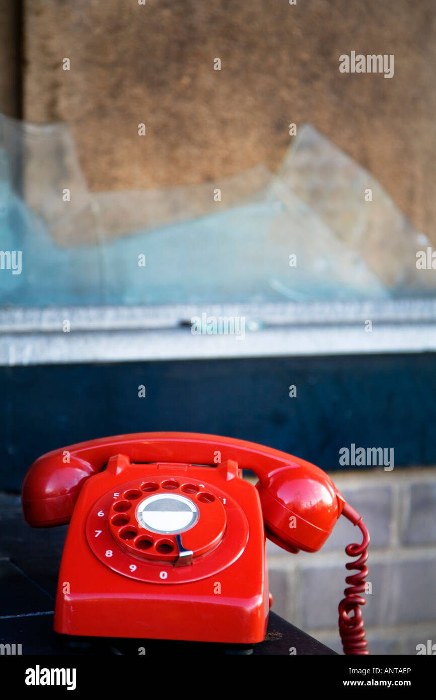 Antico Regno Unito telefono rosso abbandonato in un abbandonato edificio vecchio Foto Stock