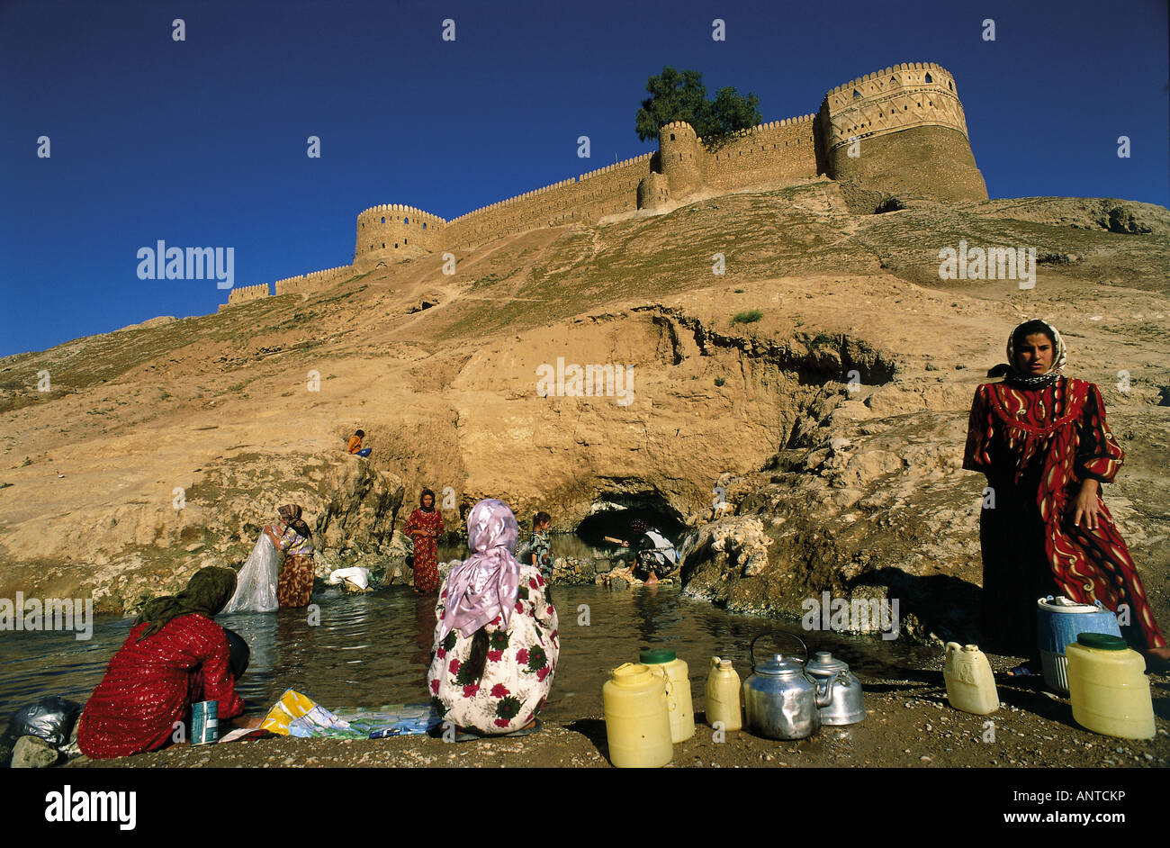 Il turkmeno e donne curde la raccolta dell'acqua da un pozzo vicino castello di Telafer Iraq Foto Stock