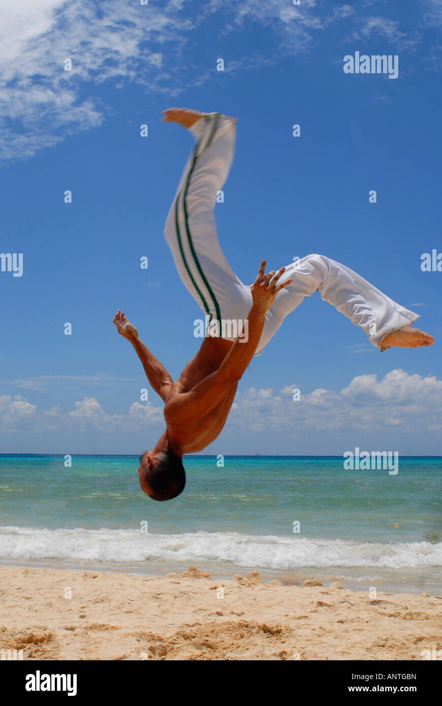 Un uomo praticando Capoeira sulla spiaggia Foto Stock