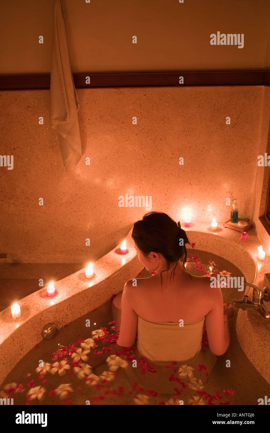 Giovane donna tenendo bagno con petali di fiori Foto Stock