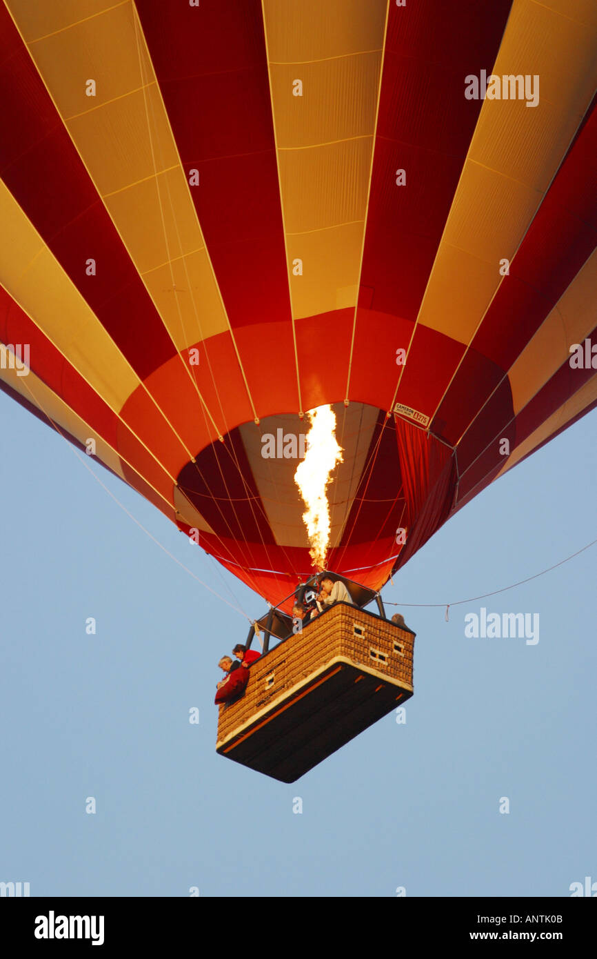 Volo in mongolfiera ad aria calda con passeggeri nel cestello e fiamme dei bruciatori Foto Stock
