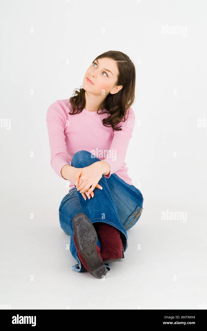 Giovane donna seduta sul pavimento Foto Stock