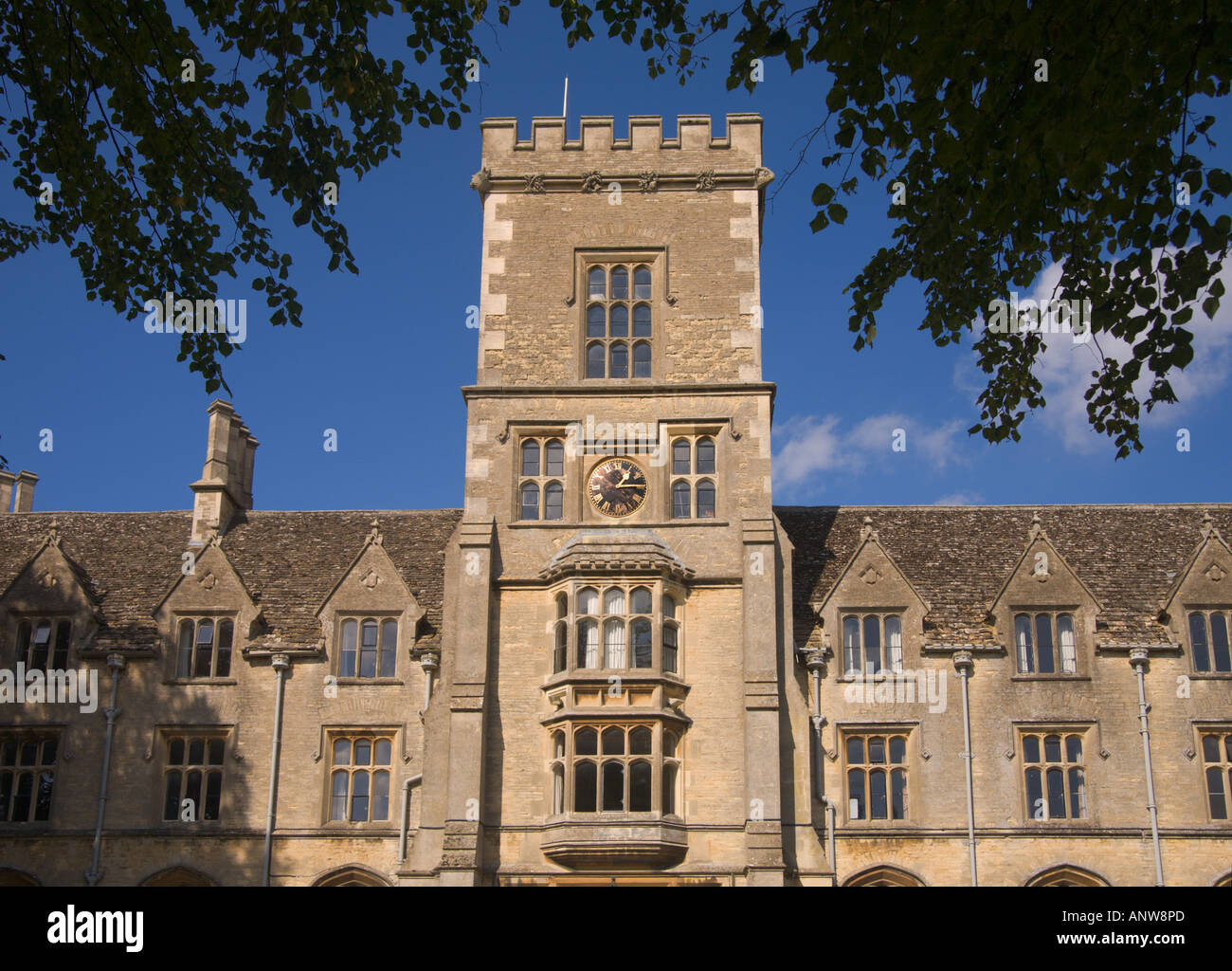 Visualizzare attraverso il telaio di rami e foglie a facciata di Royal Agricultural College di Cirencester Gloucestershire in Inghilterra Foto Stock