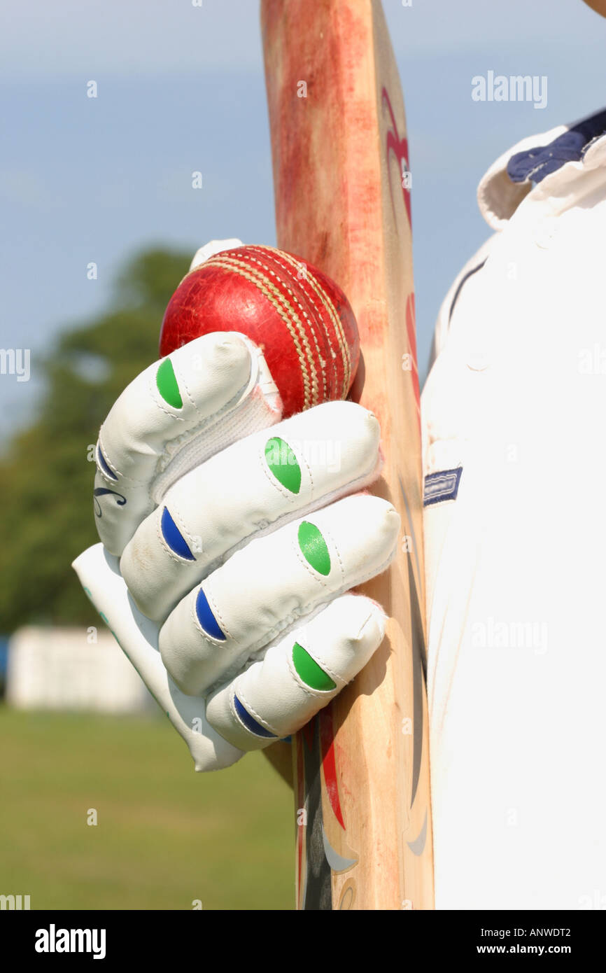 Giocatore di cricket con pelle di colore rosso sfera willow mazza di legno e dei guanti imbottiti Foto Stock