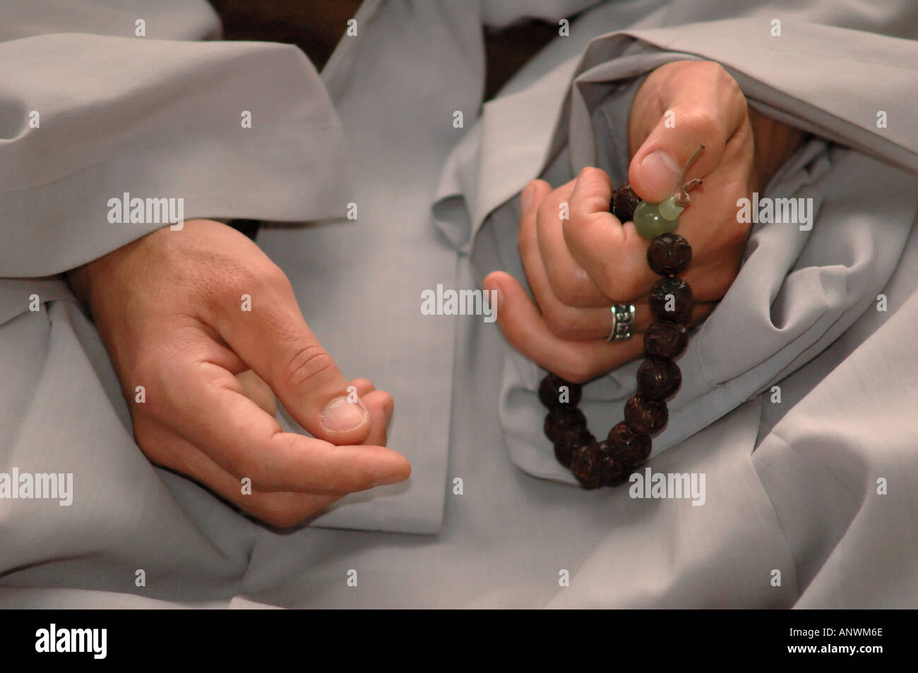 Uomo che fa del mantra con una mala un rosario buddista Foto Stock