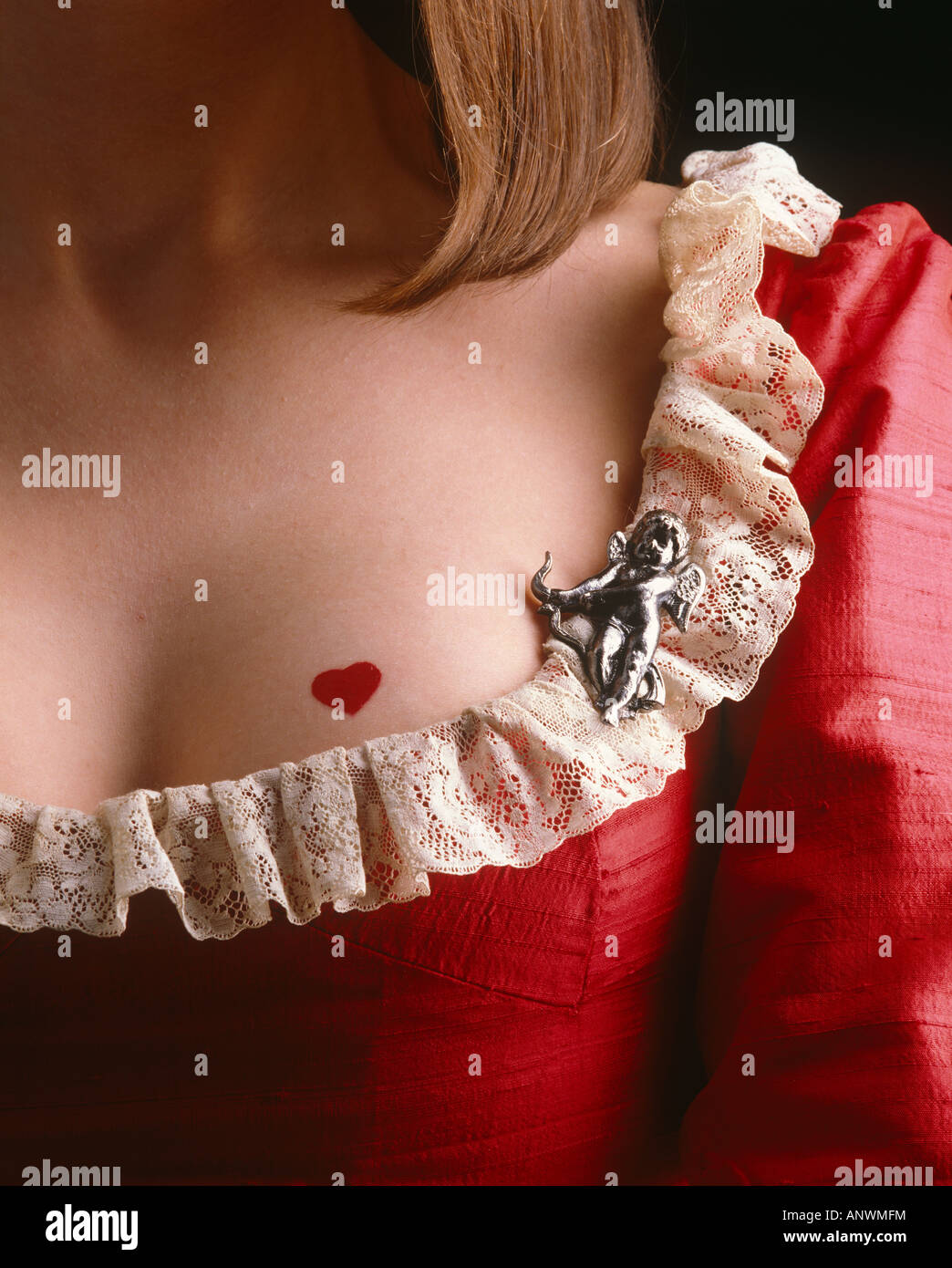 Ragazza con cuore di San Valentino sulla scissione e cupido spilla sul vestito rosso Foto Stock