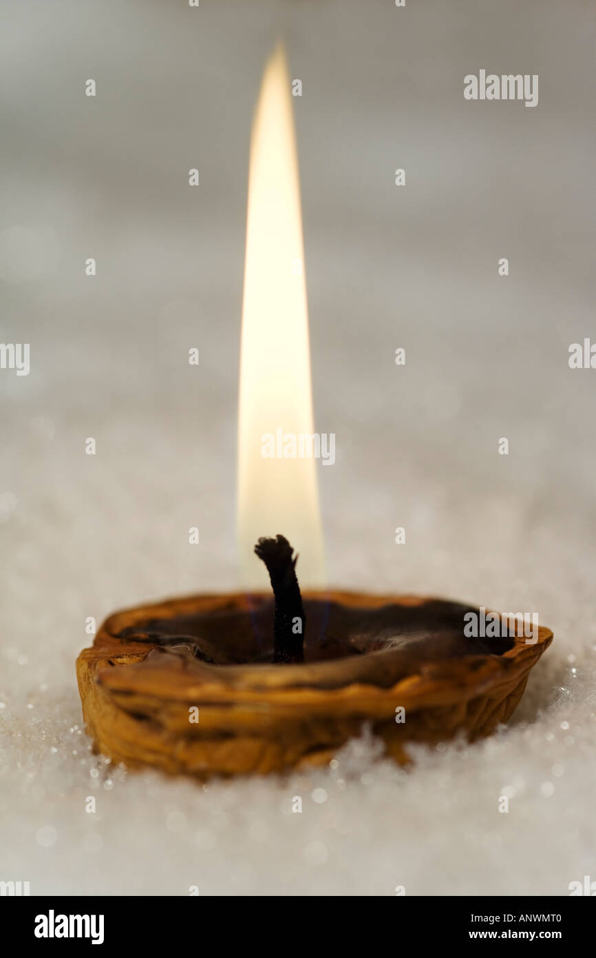 Breve con candela che brucia la posa in snow Foto Stock