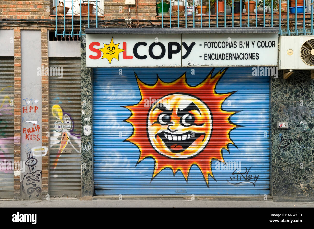 Dipinto di sun faccia su serrande, copisteria, Murcia, Spagna Foto Stock