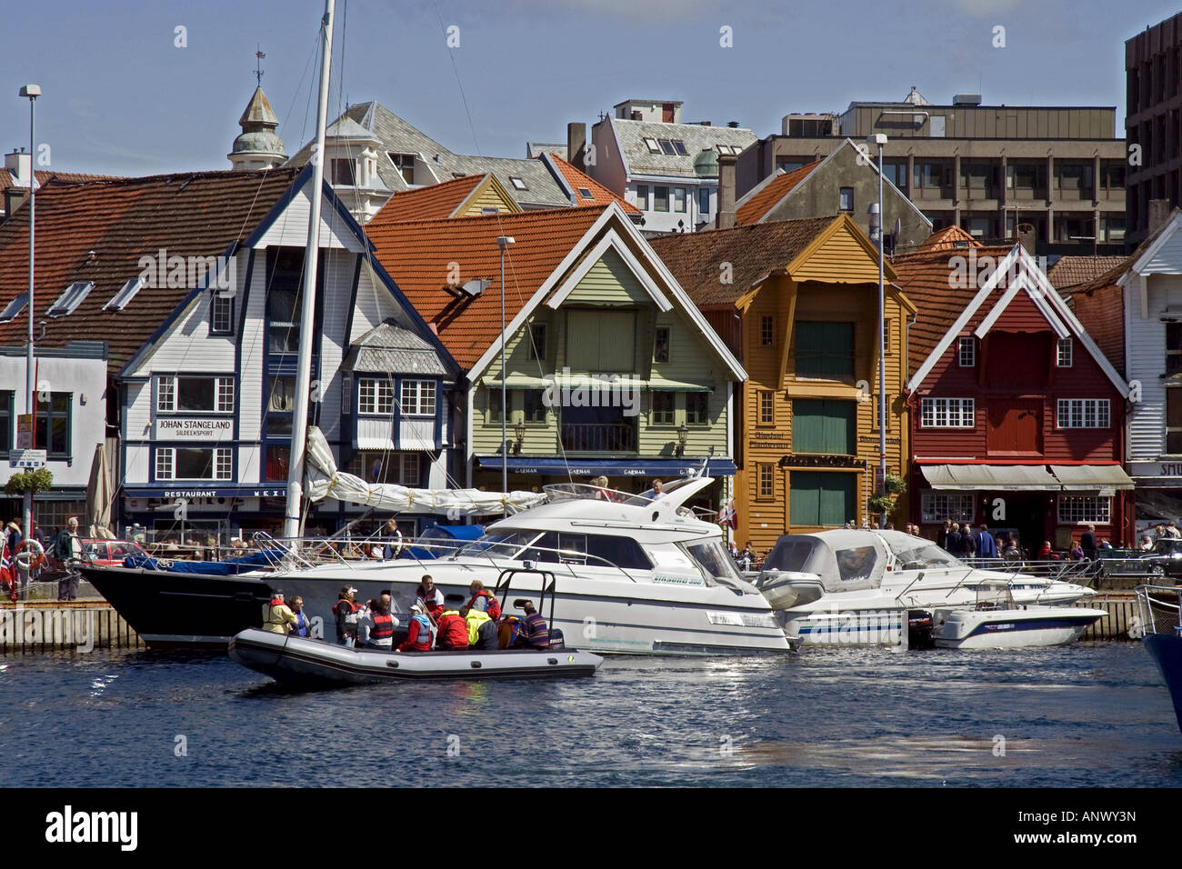 Barche, vecchi edifici e persone nel porto del centro di Stavanger, Norvegia Foto Stock