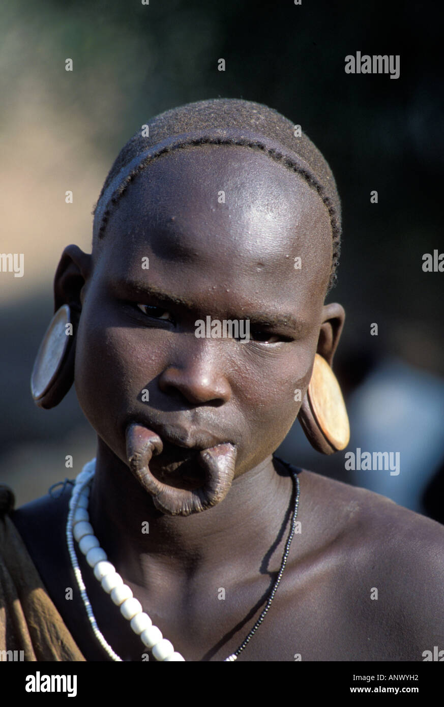 Africa, Etiopia, Omo regione, giovane Mursi con un orecchio tradizionali piastre, ma senza il labbro piastra (MR) Foto Stock