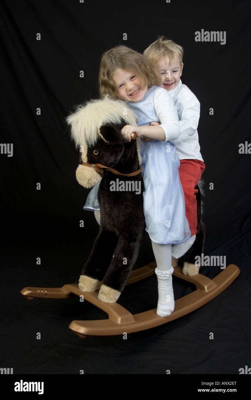 I bambini su un cavallo a dondolo Foto Stock