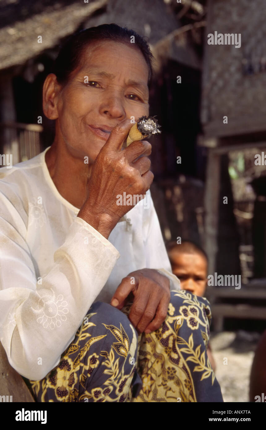 Una vecchia donna Kachin soffi su una mano-laminati cheroot, Maukkadaw, Stato Kachin, MYANMAR Birmania, in Asia. Foto Stock