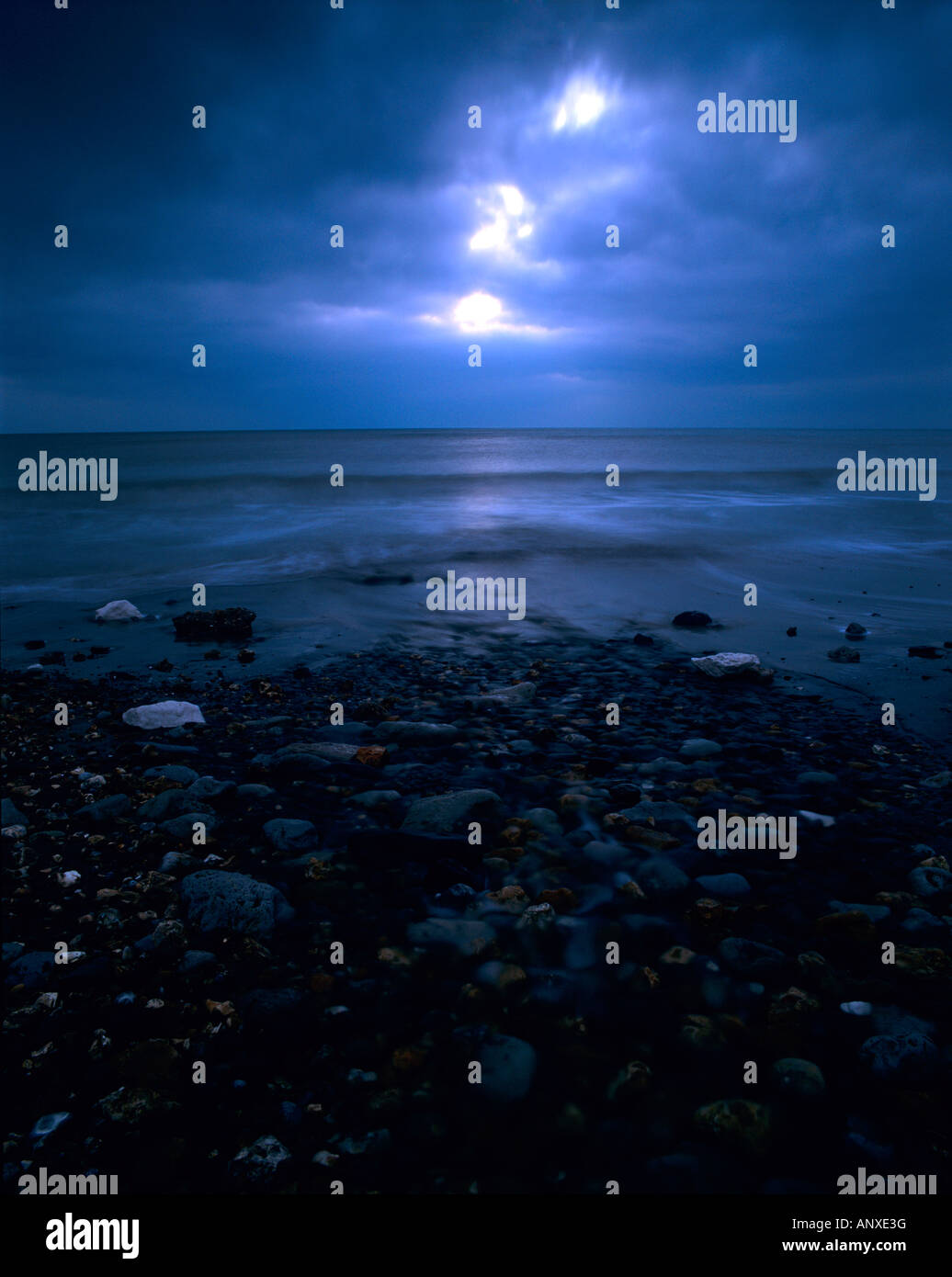 Cielo minaccioso al tramonto tramonto su un inverni freddi giorno sulla riva del mare spiaggia affacciata sul mare con nuvole temporalesche attraverso il cielo Foto Stock