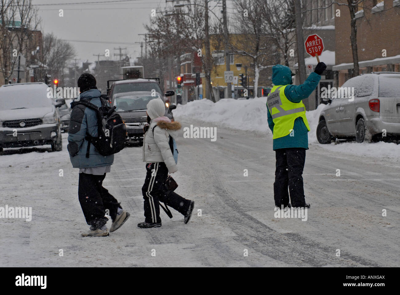 I bambini della scuola di attraversare una via durante una tempesta di neve di Montreal, Canada Foto Stock